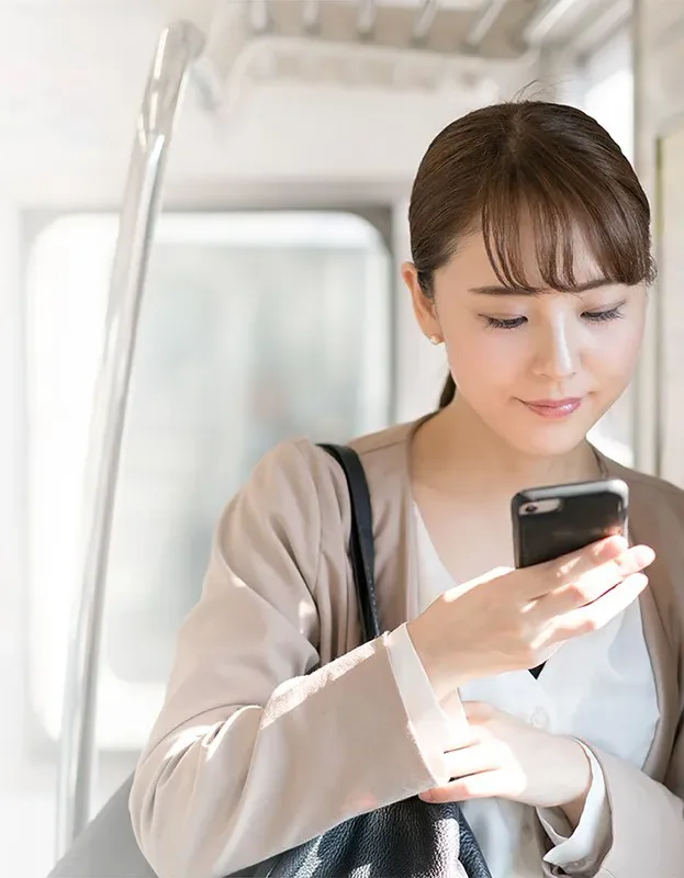 電車内でスマートフォンを読む女性
